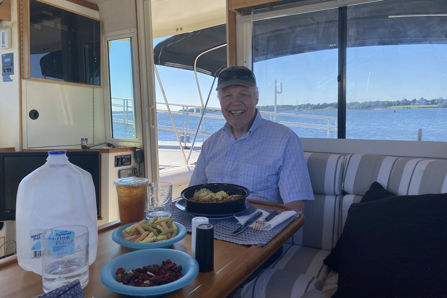 A man sitting in a boat at a table with food on it