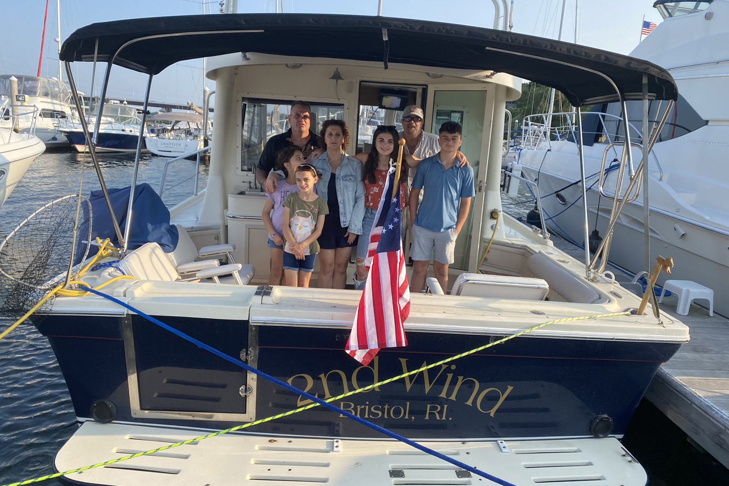 Group of prople standing facing forward on a boat seagulls flying